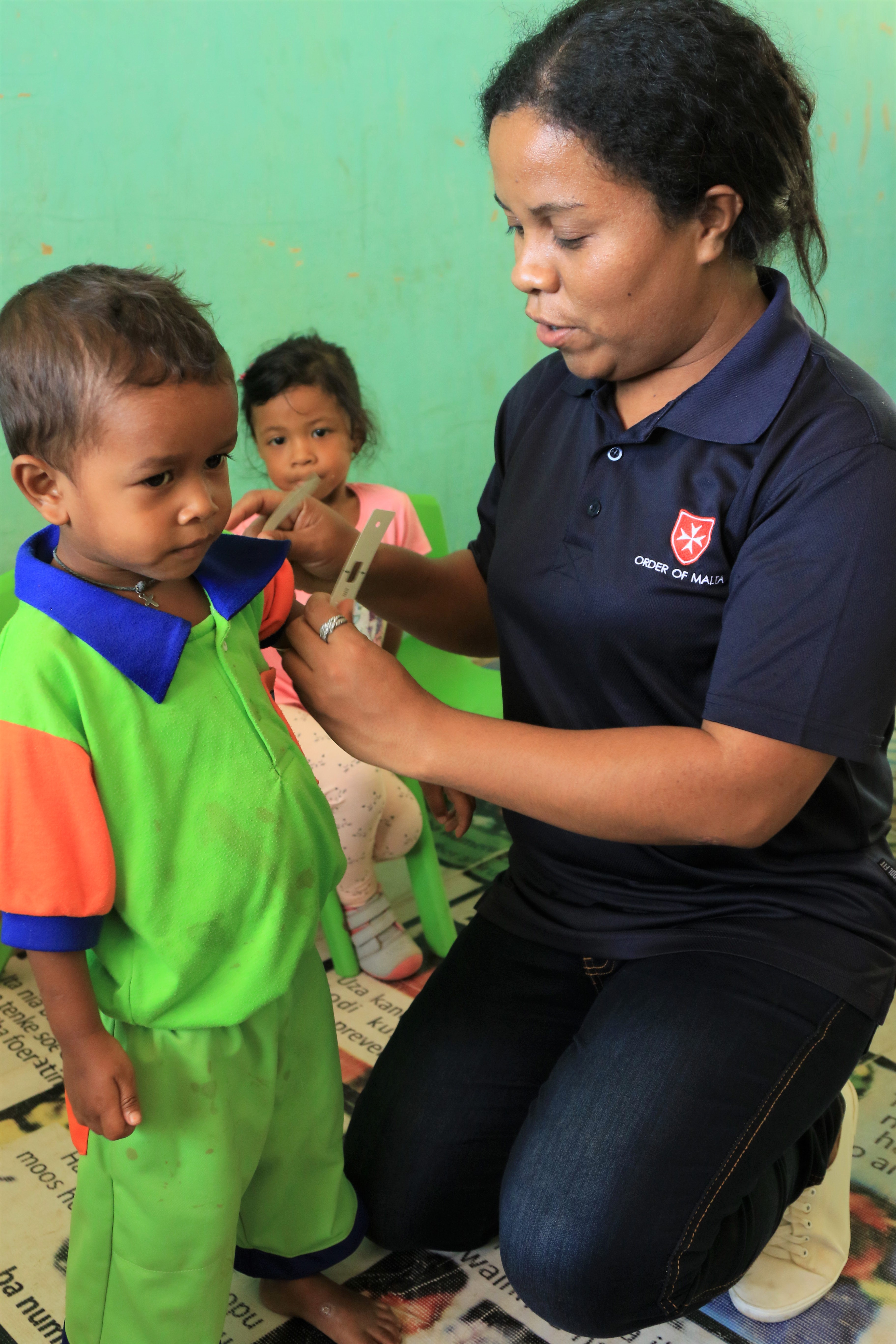 Ai-pelu outreach - Dr. Joaquina measures the MUAC of a child